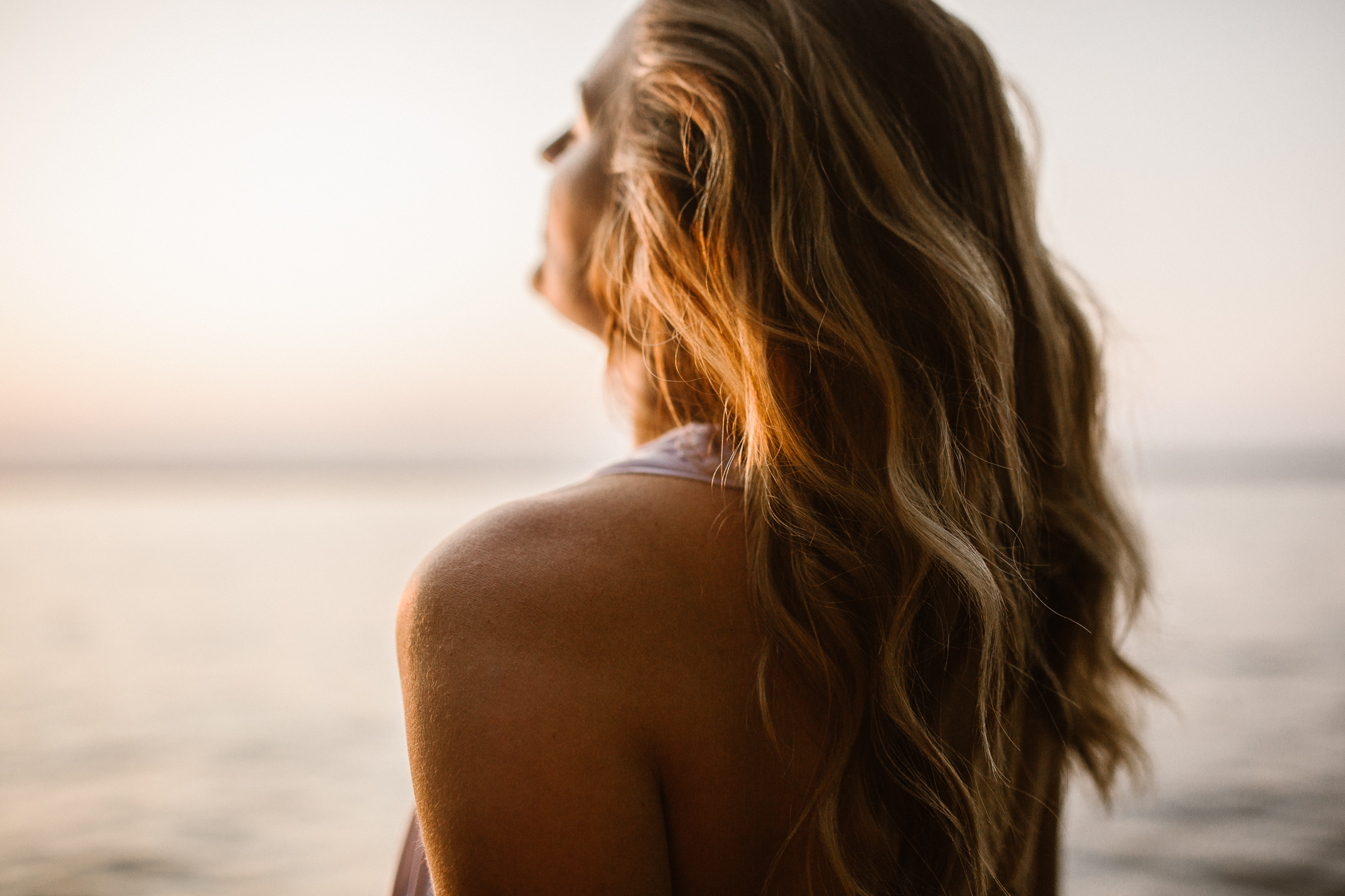 Captivating woman in an intimate lake session during a summer sunset.
